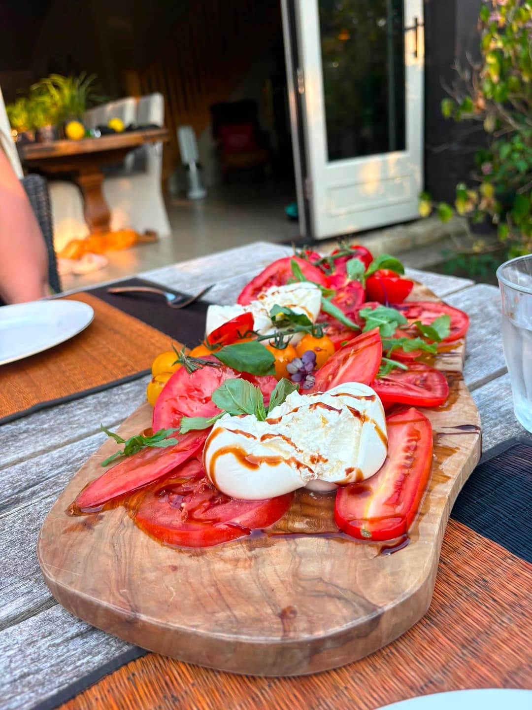 Burrata and heritage tomatoes served outdoors